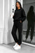 Black crewneck sweatshirt and matching joggers worn with white sneakers