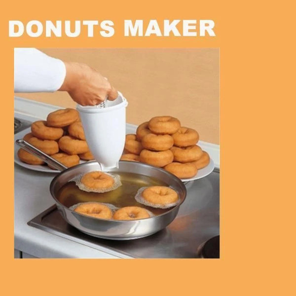 Hand using a manual batter dispenser over donuts cooking in a pan