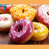 Assorted decorated ring donuts on a wooden surface