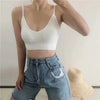 White ribbed V-neck bralette worn with blue jeans, front view