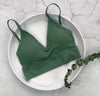 Dark green ribbed V-neck bralette displayed on a round tray