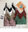 Ribbed bralettes with slim shoulder straps arranged on a white surface