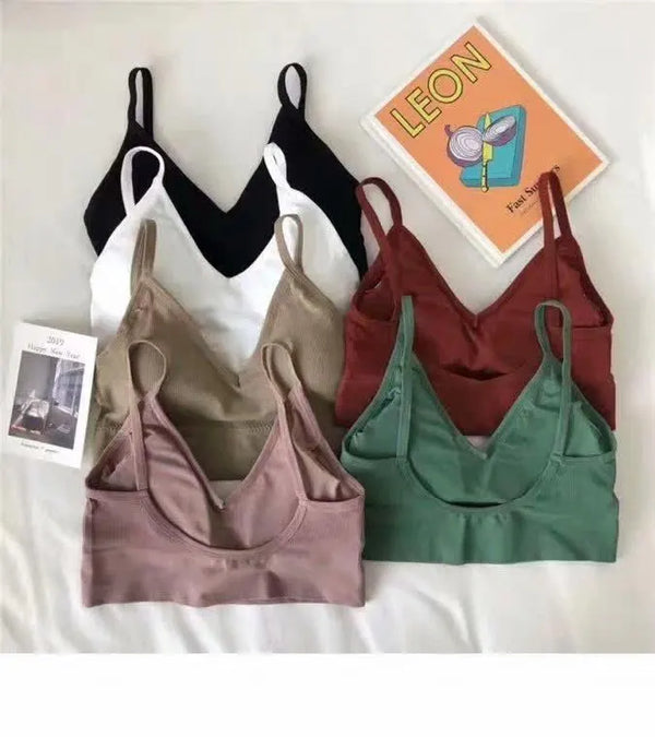 Ribbed bralettes with slim shoulder straps arranged on a white surface