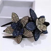 Blue and gold rhinestone flowers on a black hair claw