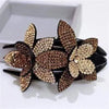 Brown and gold rhinestone flowers on a black hair claw