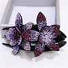 Purple rhinestone flower cluster on a black hair claw