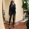 Black fitted stirrup leggings worn with a black blazer in a mirror outfit photo