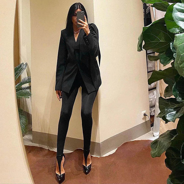 Black fitted stirrup leggings worn with a black blazer in a mirror outfit photo