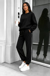 Black crewneck sweatshirt and matching joggers worn with white sneakers